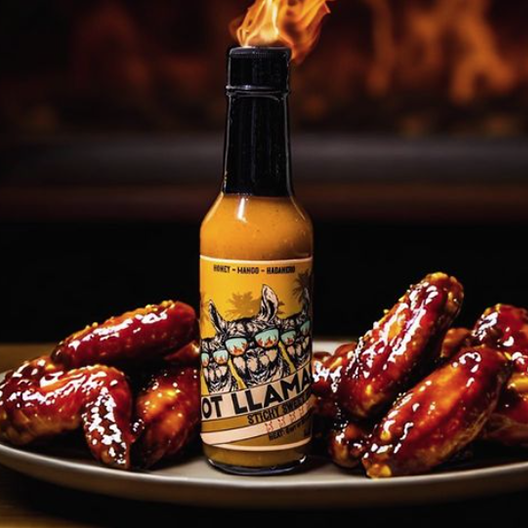 hot sauce bottle with  custom hot sauce label on plate with chicken wings